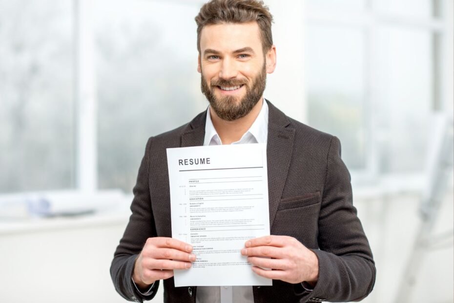 Homem profissional sorridente de terno segurando currículo em escritório moderno